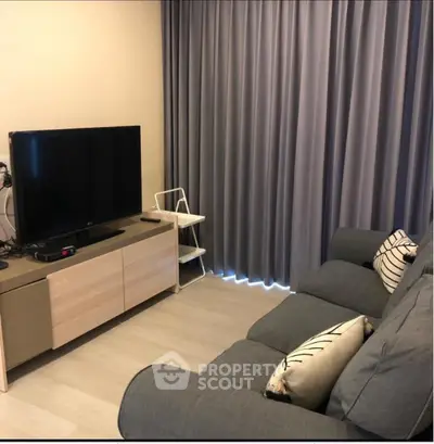 Cozy living room with modern sofa and entertainment center, perfect for relaxation.