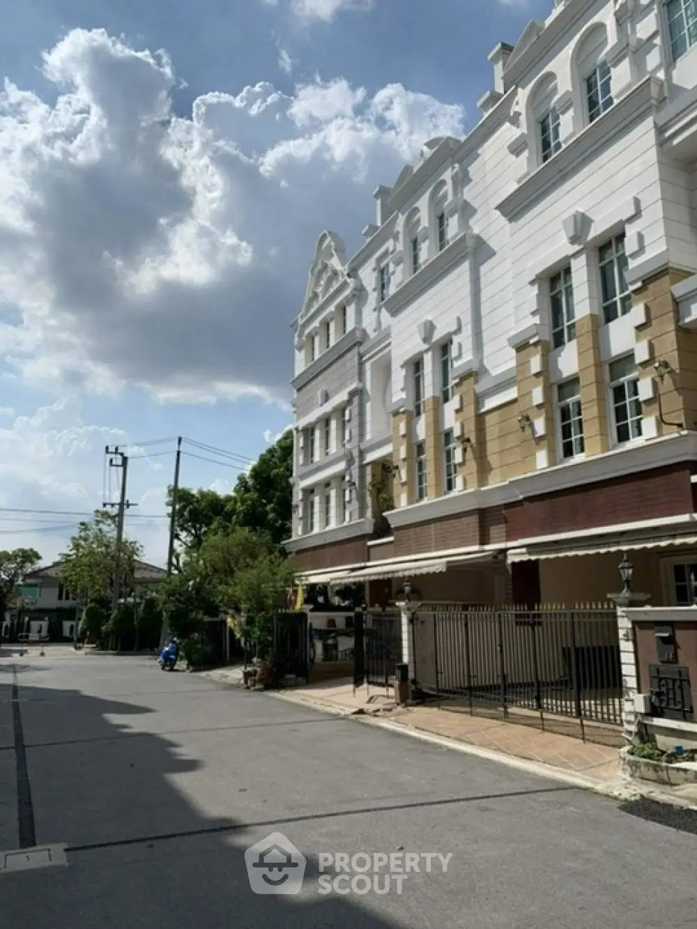 Elegant townhouse exterior with classic architecture and sunny street view
