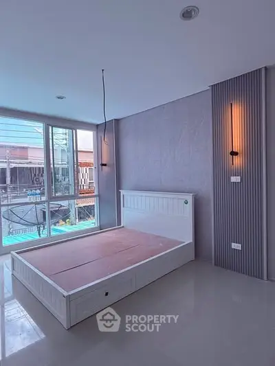 Modern bedroom with large windows and stylish lighting in a contemporary apartment.