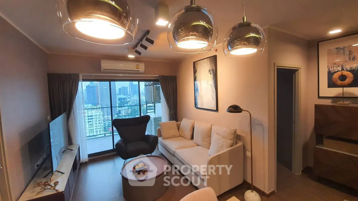 Modern living room with city view, stylish lighting, and cozy seating area in a high-rise apartment.