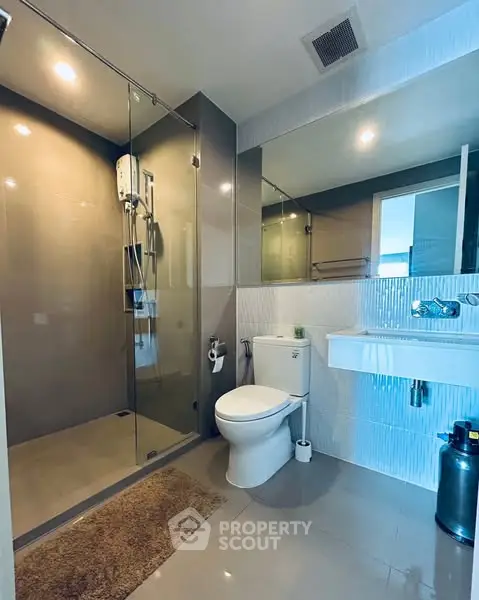 Modern bathroom with glass shower and sleek fixtures in a contemporary home.