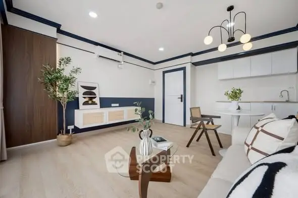 Modern living room with stylish decor and open kitchen layout, featuring elegant lighting and contemporary furniture.