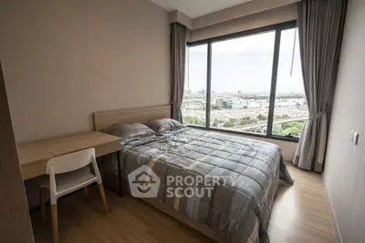 Modern bedroom with large window offering city view, featuring a cozy bed and a study desk.