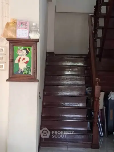 Charming wooden staircase with decorative art and storage space underneath.