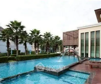 Luxurious residential pool area with palm trees and modern architecture.