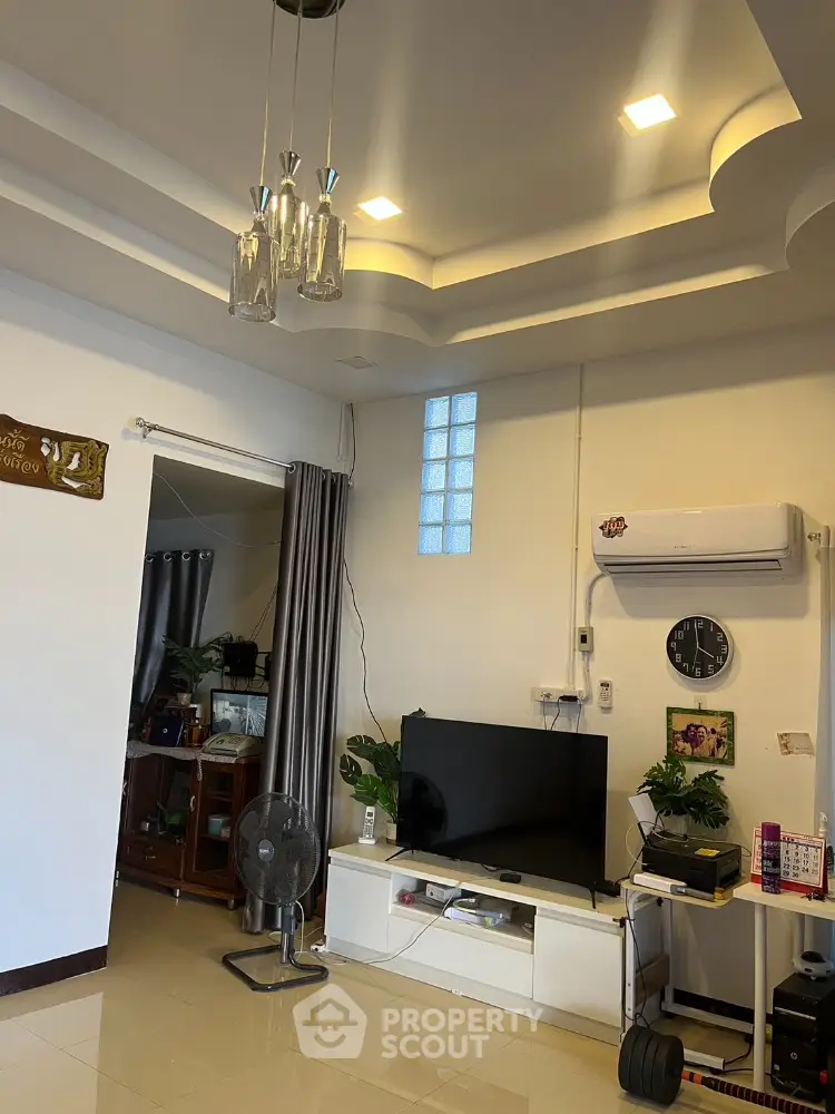 Modern living room with stylish ceiling lights and wall-mounted TV