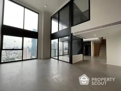 Spacious modern living room with floor-to-ceiling windows and city view