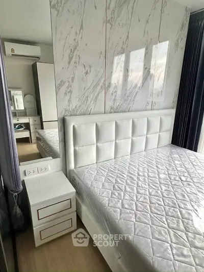 Modern bedroom with marble accent wall and stylish furniture in a contemporary apartment.