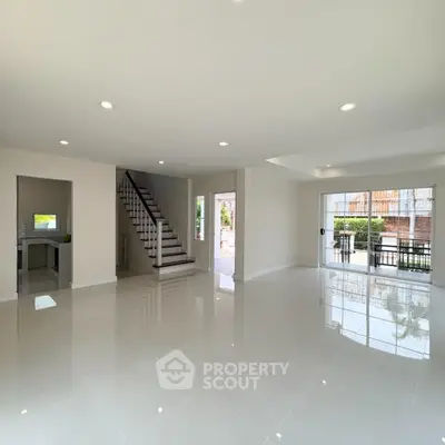 Spacious modern living room with glossy tile flooring and staircase in a bright open layout.