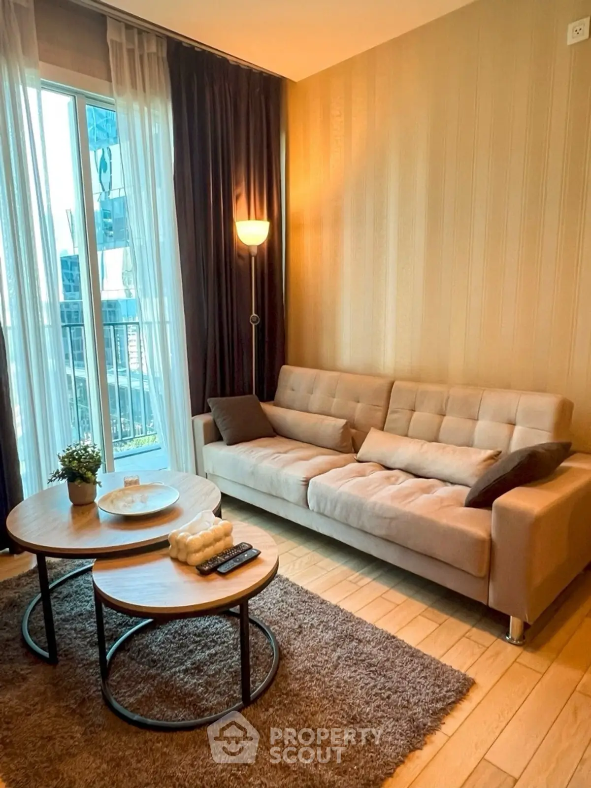 Cozy living room with modern sofa and coffee table near a bright window.