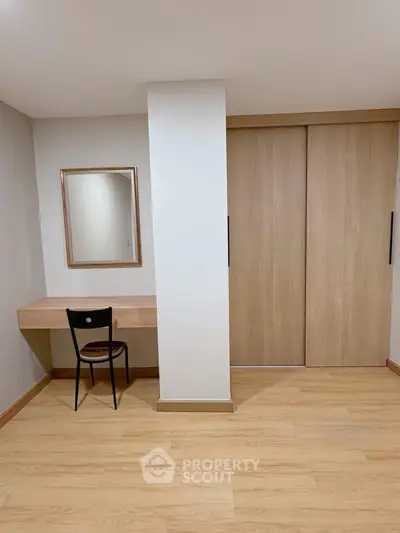 Minimalist study area with wooden desk and chair, perfect for productivity.