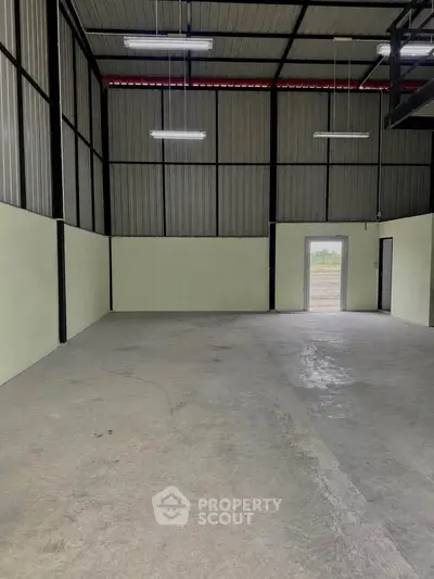 Spacious industrial warehouse with high ceilings and ample natural light, perfect for storage or manufacturing needs.
