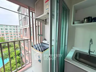 Compact balcony with washing machine and sink overlooking pool and garden view