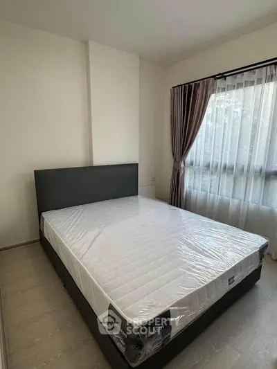 Spacious bedroom with large window and modern bed frame