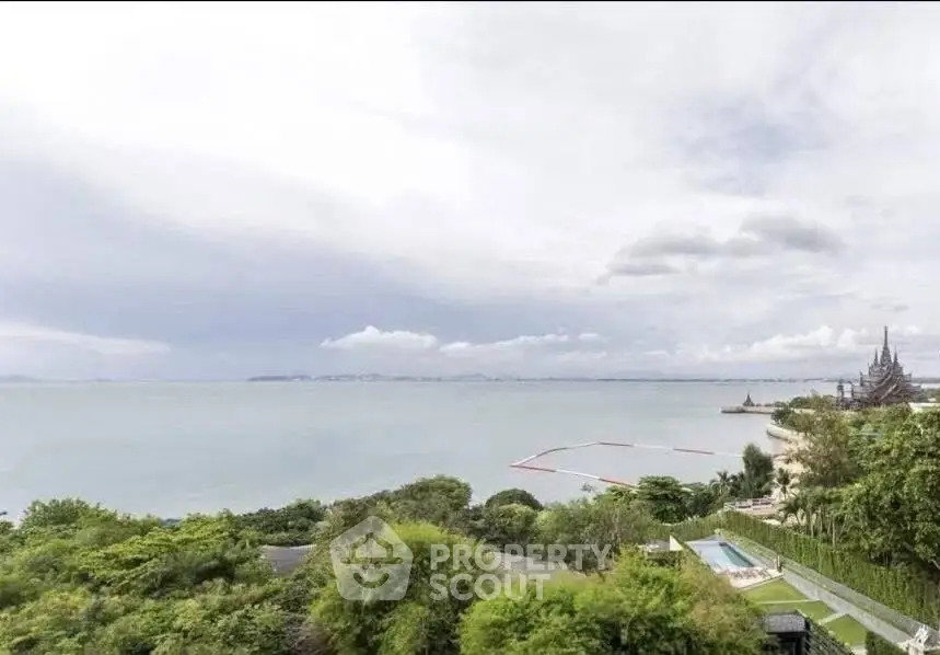 Stunning ocean view from a high-rise property overlooking lush greenery and distant horizon.