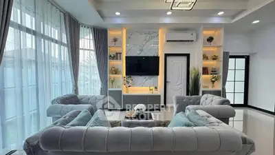 Luxurious living room with elegant sofas and modern decor, featuring large windows and stylish lighting.