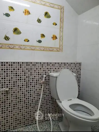Charming bathroom with unique fish-themed wall tiles and modern fixtures.