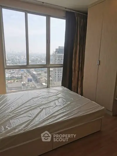 Spacious bedroom with city view in modern high-rise apartment