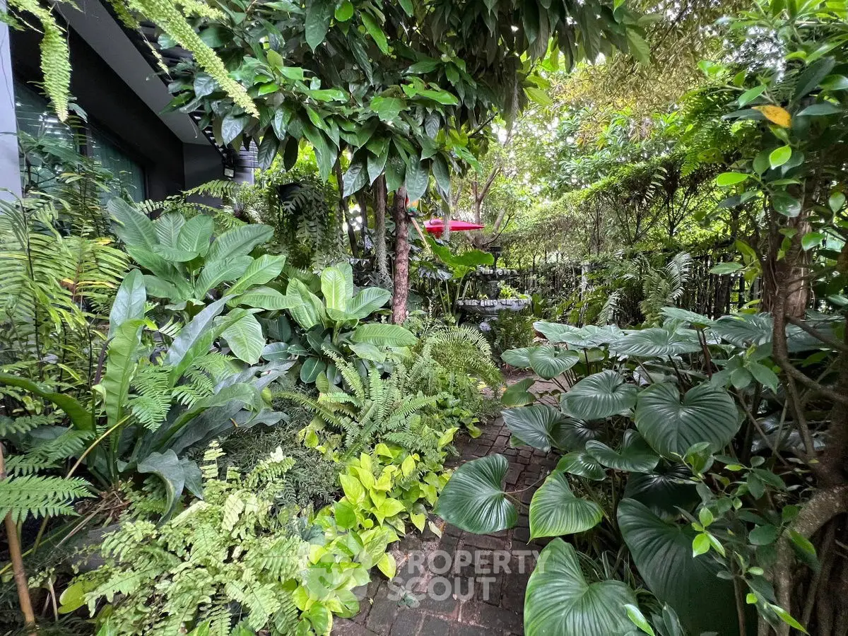 Lush garden pathway surrounded by vibrant greenery and tropical plants