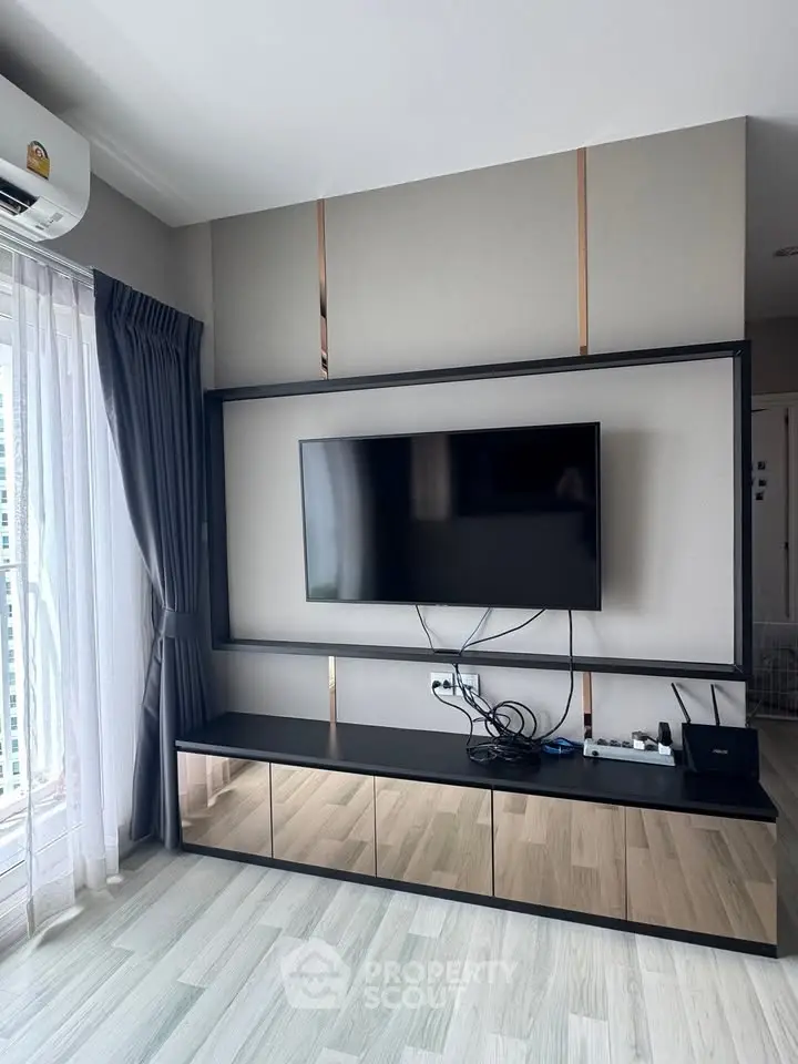 Modern living room with sleek TV setup and floor-to-ceiling windows