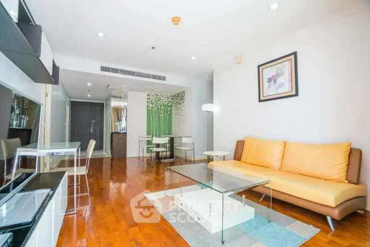 Modern living room with sleek furniture and wooden flooring, open layout design.