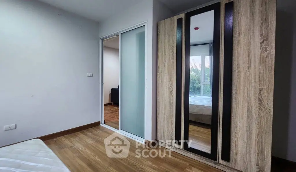 Modern bedroom with wooden flooring and mirrored wardrobe