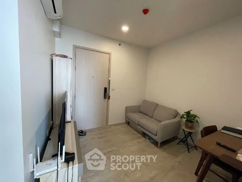 Cozy modern living room with sofa, TV, and dining area in compact apartment