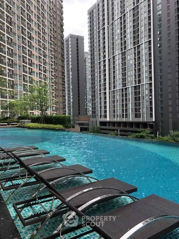 Luxurious high-rise apartment complex with stunning poolside view and modern architecture.