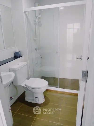 Modern bathroom with glass shower enclosure and sleek fixtures.