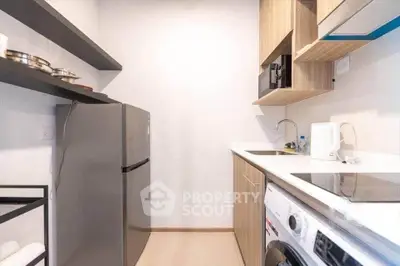 Modern kitchen with sleek appliances and minimalist design, featuring a washing machine and ample storage.