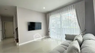 Modern living room with large window and sleek gray sofa, perfect for relaxation and entertainment.