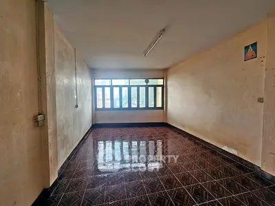 Spacious empty room with tiled floor and large windows, ideal for customization.