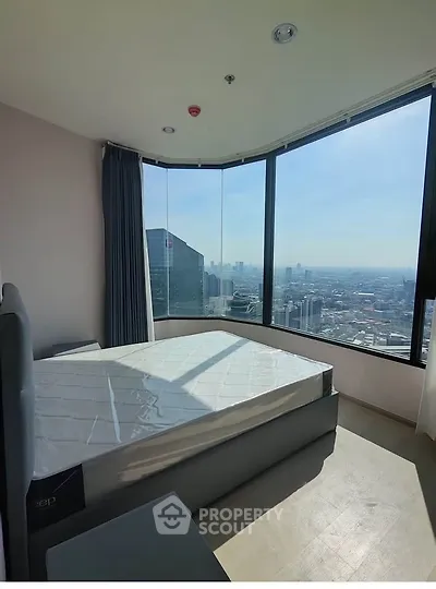 Stunning bedroom with panoramic city view in high-rise apartment