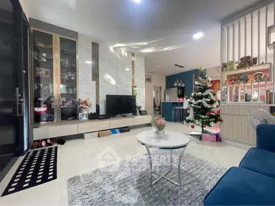 Modern living room with Christmas decor, sleek furniture, and elegant marble accents.
