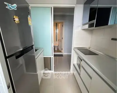 Modern kitchen with sleek appliances and view into adjacent room