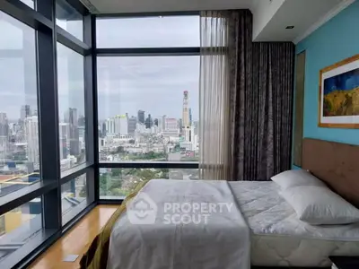 Luxurious bedroom with stunning city view from floor-to-ceiling windows in high-rise apartment.