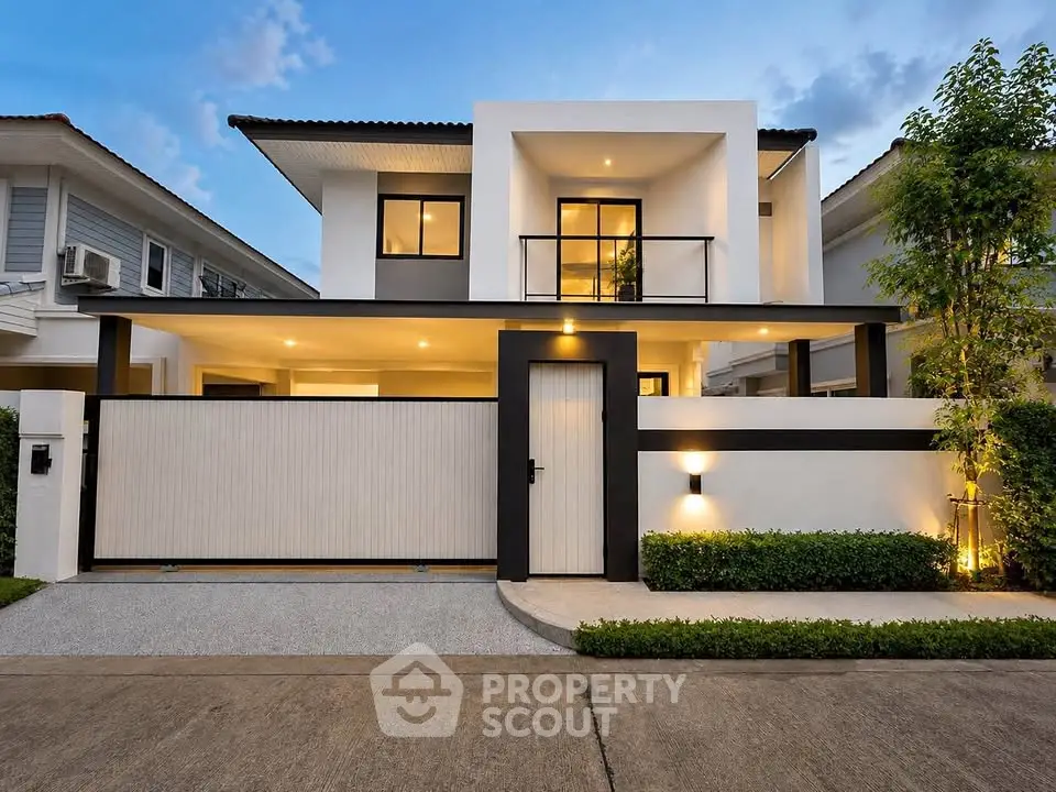 Modern two-story house with sleek design and well-lit exterior, featuring a spacious driveway and lush greenery.