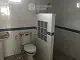 Spacious bathroom with modern fixtures, including a large shower area and classic white tiling, offering a clean and serene space.