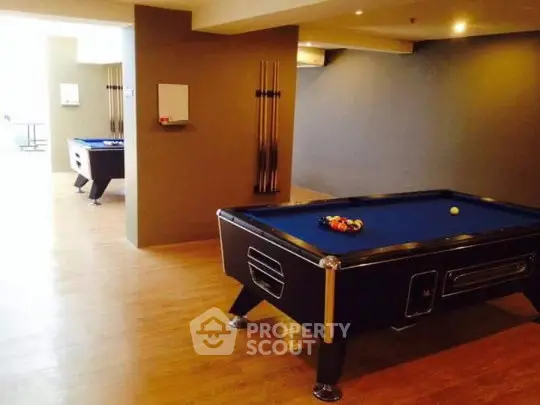 Spacious recreational area with pool tables in modern apartment complex.