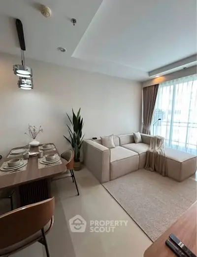 Modern living room with cozy beige sofa and elegant dining area