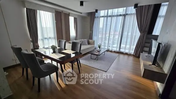 Spacious modern living room with large windows and elegant decor