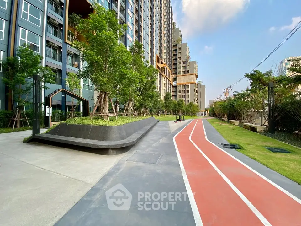 Modern residential building with landscaped garden and jogging track