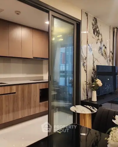 Modern kitchen with sleek design and marble accents, featuring open layout and stylish cabinetry.