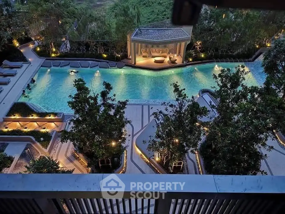 Luxurious outdoor pool area with elegant landscaping and ambient lighting at a high-end residential complex.