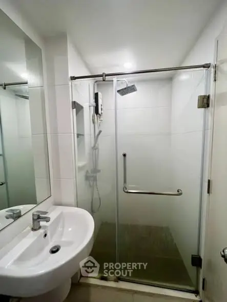 Modern bathroom with glass shower enclosure and sleek fixtures.