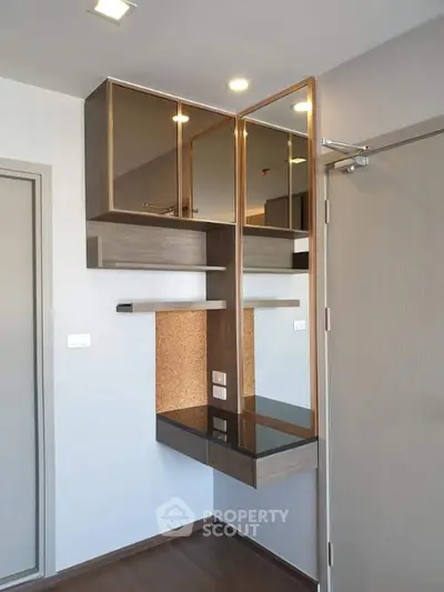 Modern interior with sleek built-in storage and mirrored cabinets in a stylish apartment.
