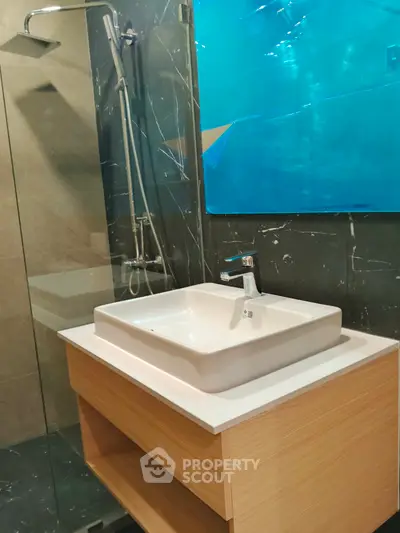 Modern bathroom with sleek sink and glass shower enclosure