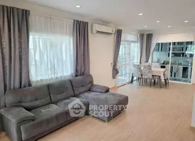 Spacious living room with modern decor and open kitchen layout, perfect for family gatherings.