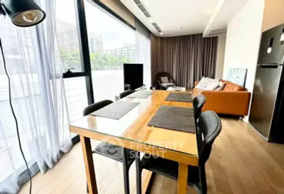 Spacious modern living room with large windows and stylish furniture in a city apartment.