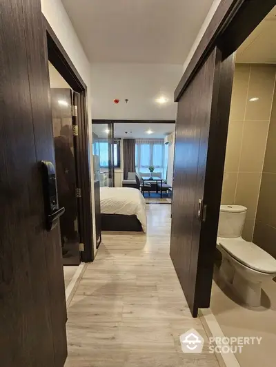 Modern apartment hallway leading to bedroom and bathroom with sleek design